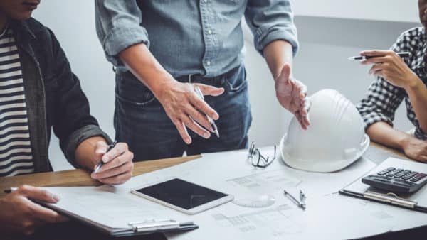 3 person analyzing construction plans