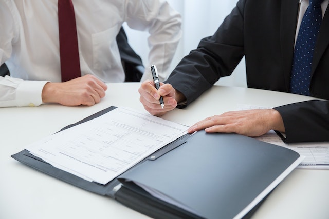 Lawyer and a man signing a document.