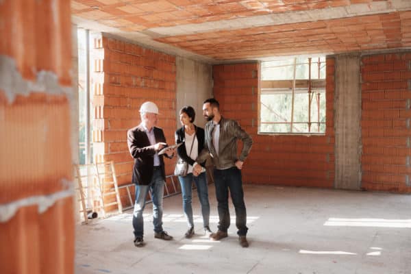 a contractor showing the building site to a couple
