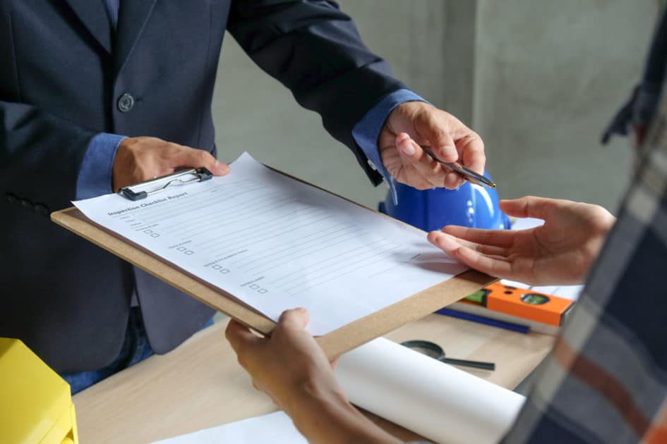 A Man Signing a Checklist Report