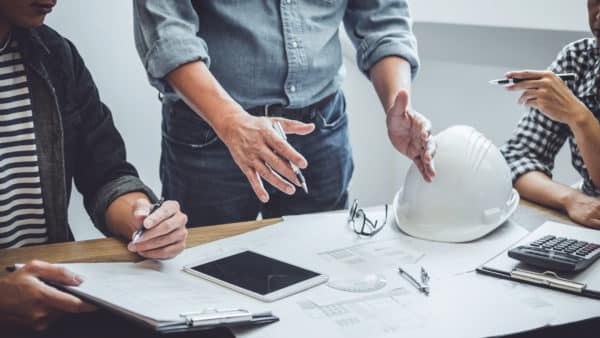 3 People working on a Construction Plan